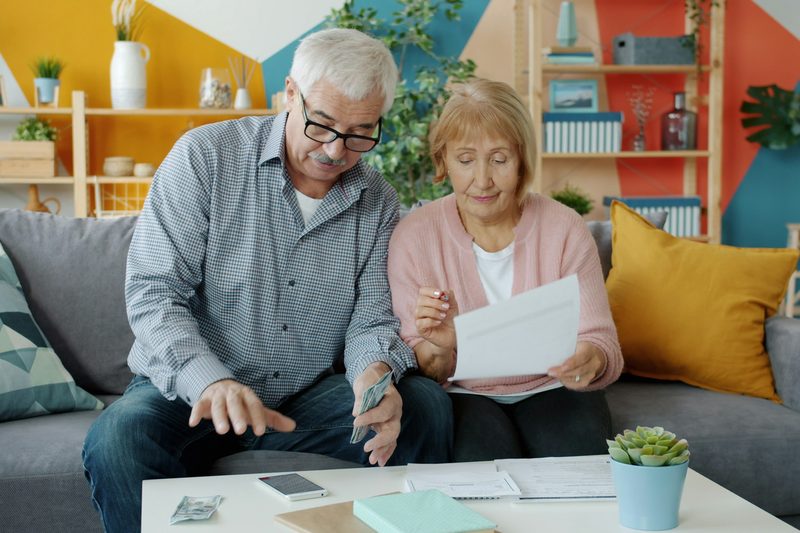Una pareja mayor revisa sus documentos en casa