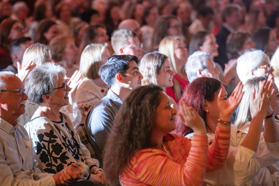 Un público de todas las edades aplaude en un auditorio